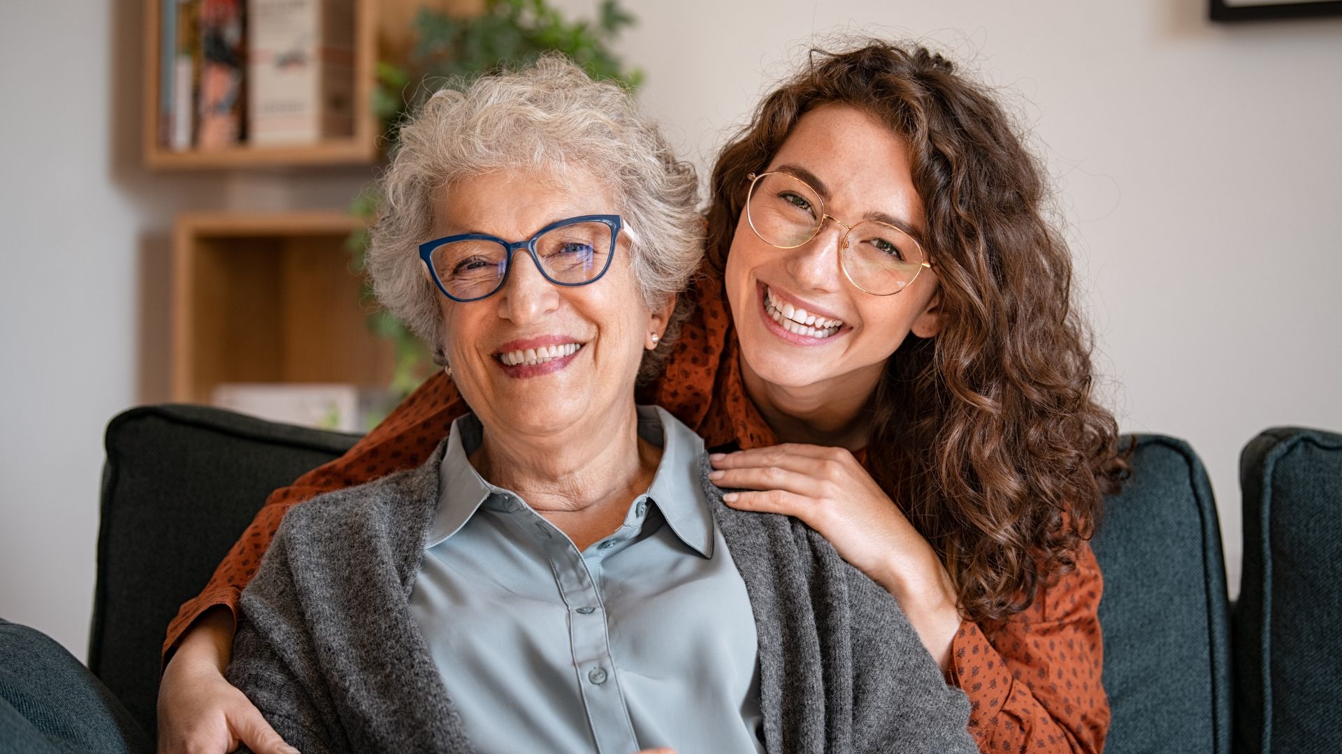 An older and a younger woman smiling because they are not worried about finances.