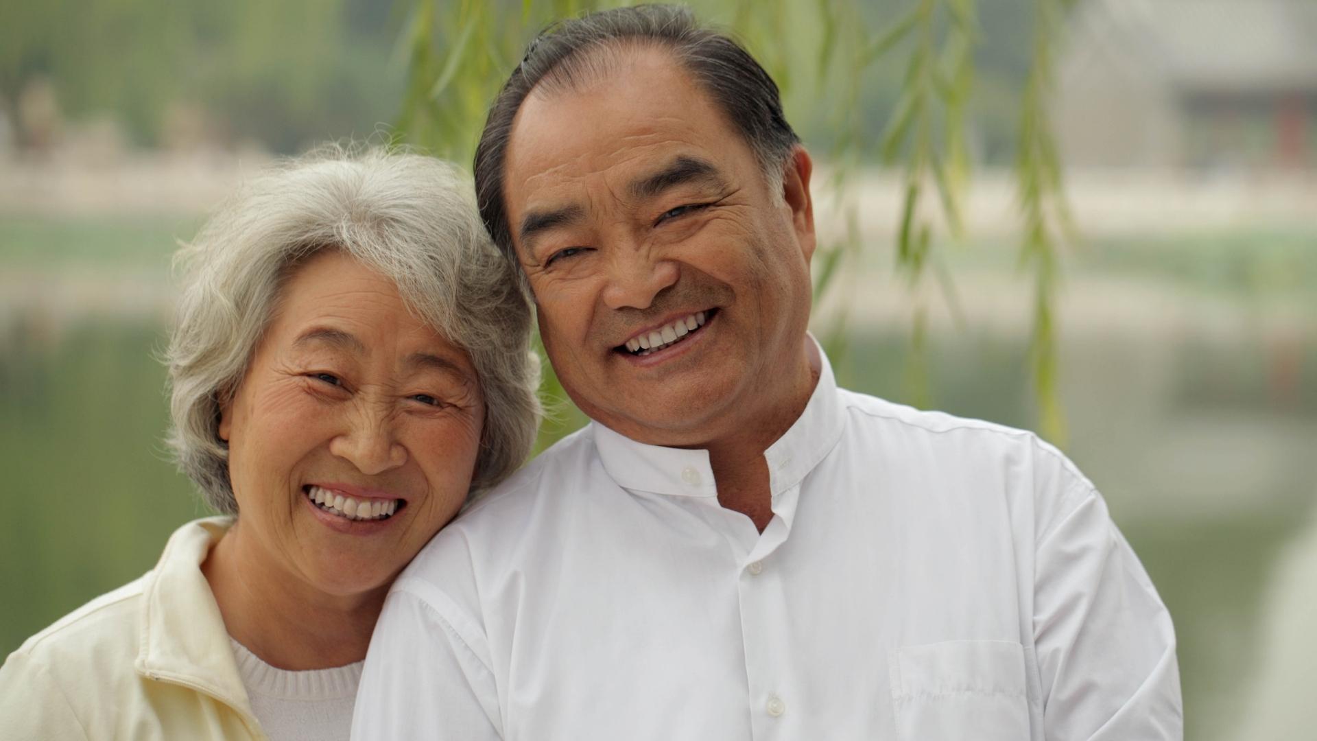 An older couple smiling at the camera.