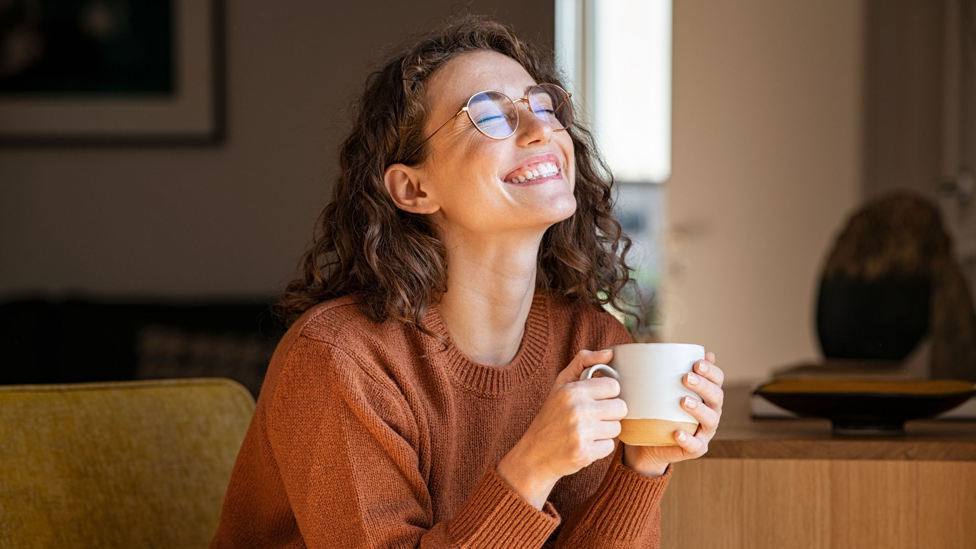 Woman drinking tea and relaxing because she didn't have to work extra hours to pay her bills.